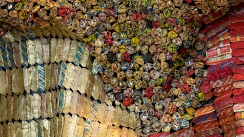 A zoomed in view of African artist El Anatsui’s Wrinkle of the Earth 2, a large three-dimensional mosaic reminiscent of a Ghanaian ceremonial cloth, created from thousands of recycled bottle tops.